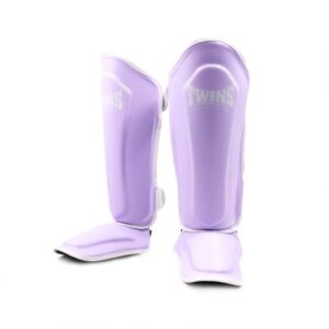 Twins SGL10 pastel lilac shin guards with white trim, showing front and angled views of the shin and instep padding.